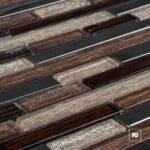 Close-up of rectangular glass tiles in brown and beige tones arranged in parallel rows.