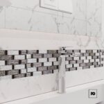 Malla30x30-nantes-cenezzia-3-ok | Plomería García Chrome bathroom faucet mounted over a white marble vanity with a glass-and-metal mosaic backsplash.